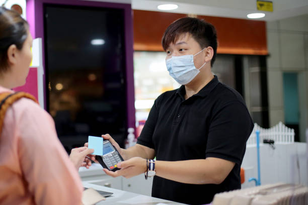 South East Asia: At The Airport - Portable Wifi Rental Service A female customer is using credit card for contactless payment to rent portable WiFi service package at Malaysia airport. contactless airport stock pictures, royalty-free photos & images