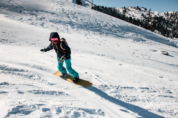 istock Woman freeriding from mountain on a professional snowboard 1212540554