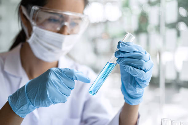 istock Scientist or medical in lab coat holding test tube with reagent, Laboratory glassware containing chemical liquid, Microscope, Biochemistry laboratory research 1212541663
