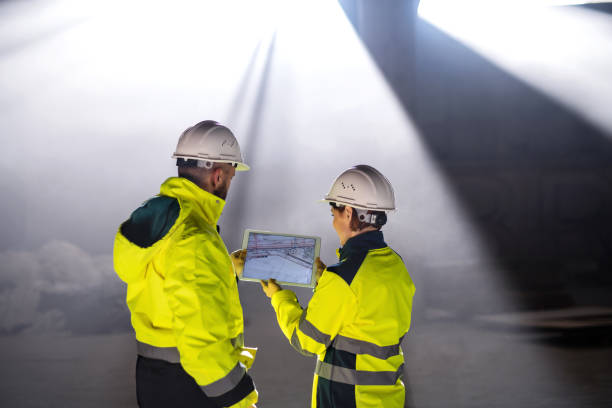 istock Rear view of engineers standing on construction site, holding tablet. 1212543227