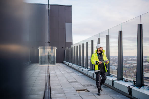 ingénieur d’homme marchant sur le chantier de construction, tenant la tablette. - condition photos et images de collection