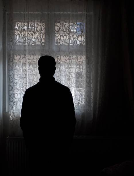 istock Dark room, bright window and man silhouette 1212544250