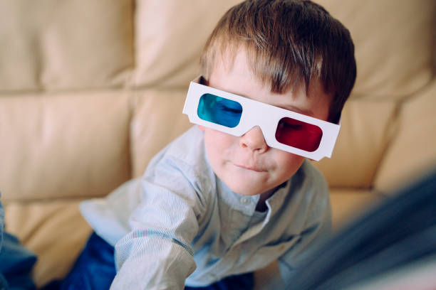 istock Cheerful little kid playing with three dimensional glasses and interactive cinema at home. 1212544560