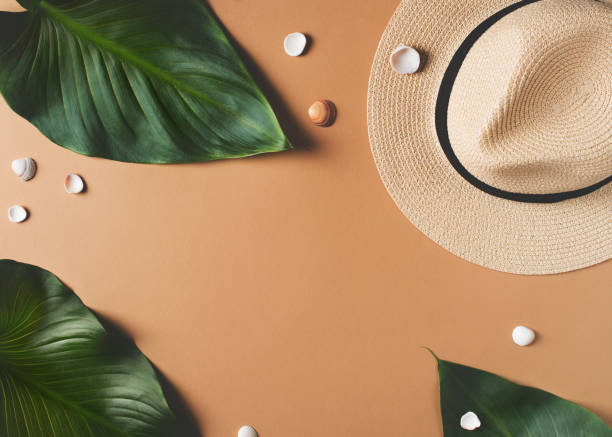 istock Vacation flat lay frame with hut, laeves and other accessories on beige background 1212544782