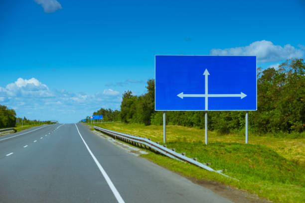 blank blue billboard with arrow directions near empty motorway