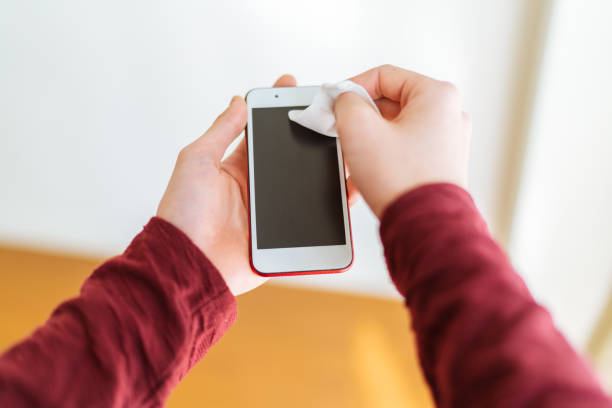 istock Man disinfecting his smart phone with wet alcohol tissue 1212545947