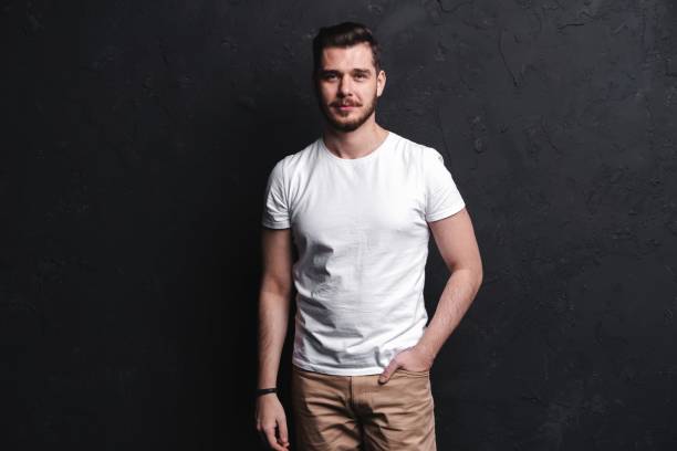 istock young fashion man posing for the camera on black background 1212548763
