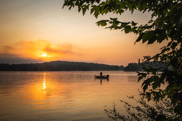 istock Fisherman on the lake at sunrise 1212550207