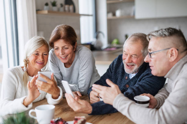 istock Group of senior friends at home, using smartphones. 1212551667