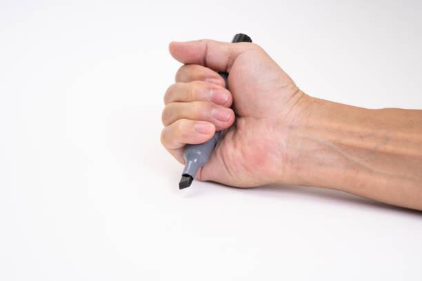 istock Man hand holding black magic marker pen writing on white background 1212552022