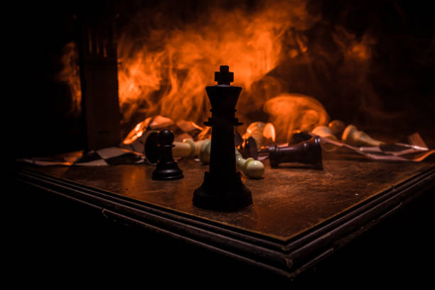 Chess board game concept of business ideas and competition. Chess figures on a dark background with broken chessboard. Creative artwork decoration. Selective focus