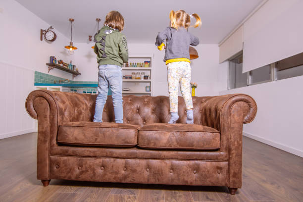 istock Kids jumping on the couch at home 1212554939