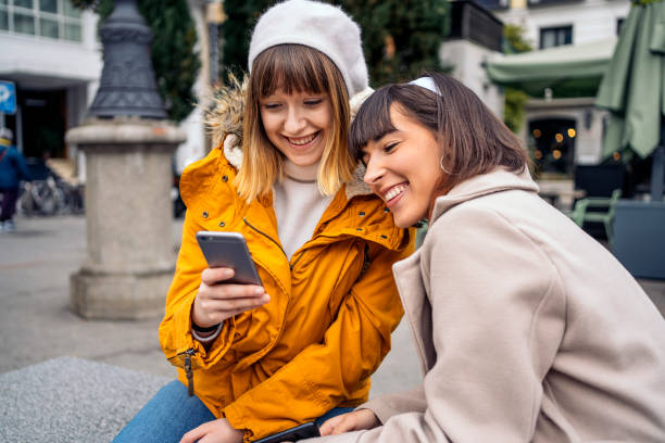 istock Two caucasian girls using a smartphone. 1212556411