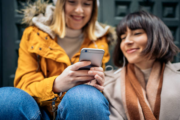 istock Two caucasian girls using a smartphone. 1212556420