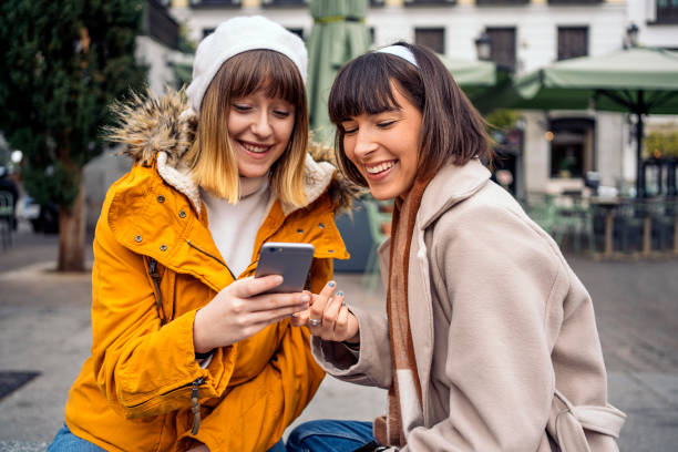 istock Two caucasian girls using a smartphone. 1212556430