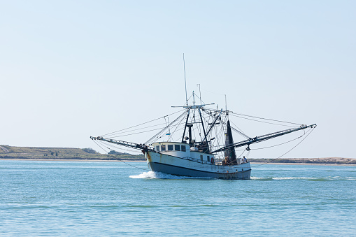 Old fishing boat navigating the Brazos Santiago Pass from the Laguna Madre into the Gulf of Mexico