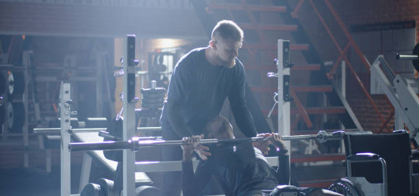 istock Wheelchair man lifting weight in gym 1212557633