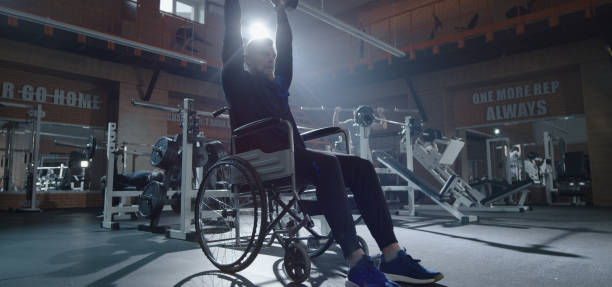 istock Wheelchair man lifting weight in gym 1212557677