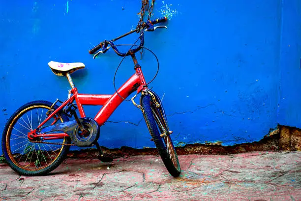 A small red bike parked on a blue wall at February in Istanbul