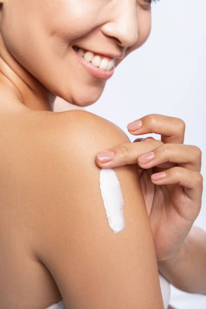 istock Happy pretty woman is applying arm cream 1212560909