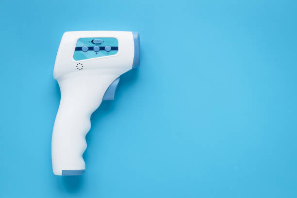 Digital medical infrared forehead thermometer gun non contact for measuring temperature, for coronavirus (COVID-19) testing. Blue background. Copy, text space. stock photo
