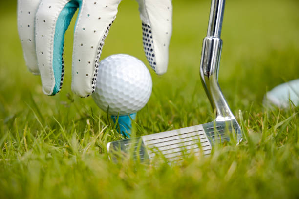 istock Hand in glove placing golf ball on tee 1212562573