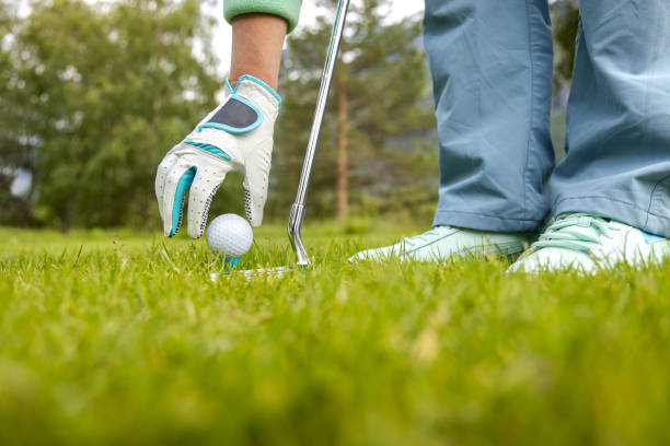 istock Hand in glove placing golf ball on tee 1212562588