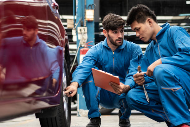 istock automotive mechanic men checking at  car tyre rubber condition needed for replacement, man pointing hand at wheel following maintenance checklist document, after service at auto repair shop concept 1212563203