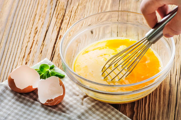 istock Whipped eggs. Woman whisking fresh eggs in glass bowl 1212565713