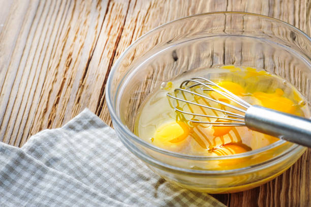 istock Whipped eggs. Woman whisking fresh eggs in glass bowl 1212565728
