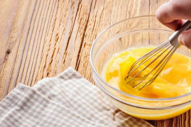 istock Whipped eggs. Woman whisking fresh eggs in glass bowl 1212565739