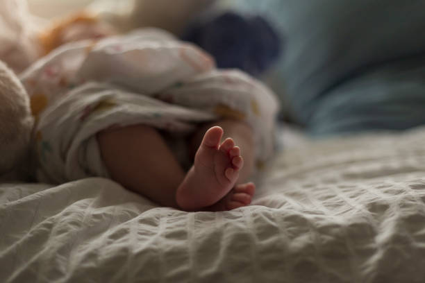 istock Newborn baby girls tiny feet 1212567107
