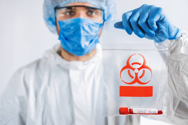 istock Scientist in biological protective costume with biohazard trasportation package. Epidemic virus outbreak concept 1212567828