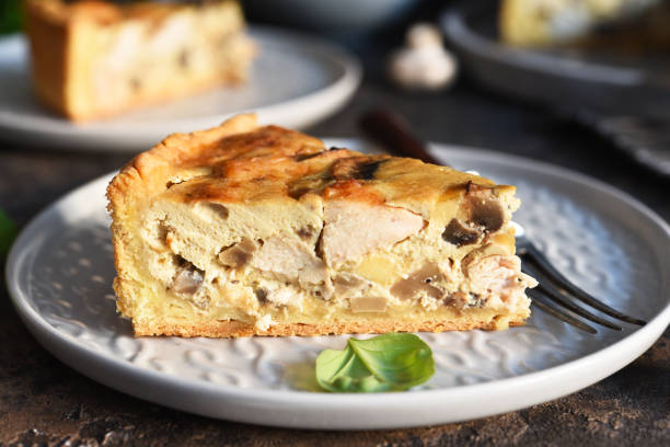 Tart slice on the kitchen table. Traditional quiche with chicken, mushrooms and cheese on a dark concrete background. Tart slice on the kitchen table. Traditional quiche with chicken, mushrooms and cheese on a dark concrete background. quiche stock pictures, royalty-free photos & images