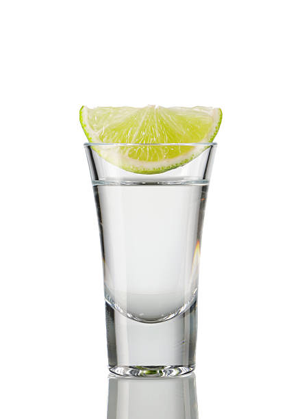 A slice of lemon in a shot of tequila stock photo