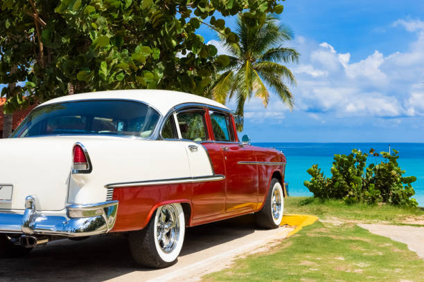 american red white 1955 classic car parked direct on the beach in varadero cuba - serie cuba reportage - varadero beach fotografías e imágenes de stock