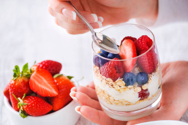 istock Yogurt with forest fruits and strawberries in background. 1212572234
