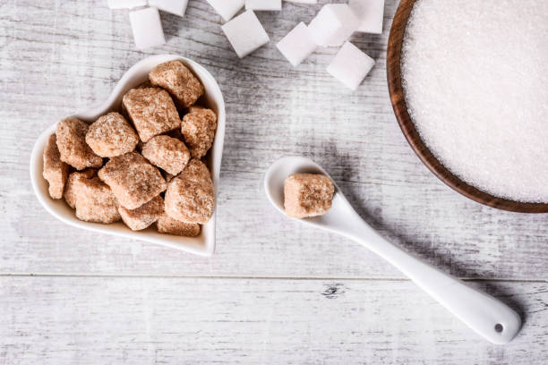 istock White fresh sugar on white table. Sugar in wood bowl. 1212572300