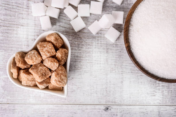istock White fresh sugar on white table. Sugar in wood bowl. 1212572311