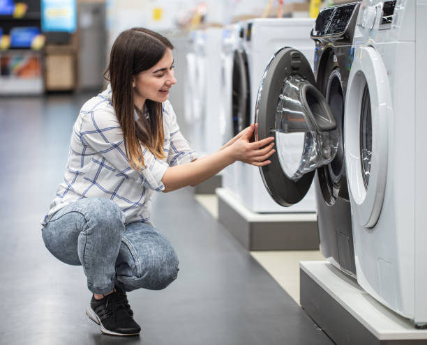 istock A young woman in a store chooses a washing machine. 1212572665
