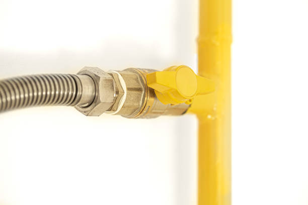 Yellow gas pipe with a valve. White background. Space for text.