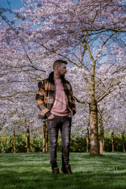 istock men walking in the public park in Amsterdam Netherlands during Spring with blooming cherry blossom trees 1212576241