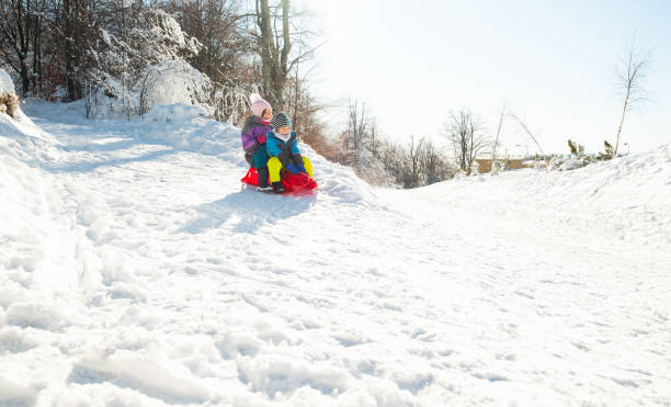istock Little boy with girl on sled 1212576266