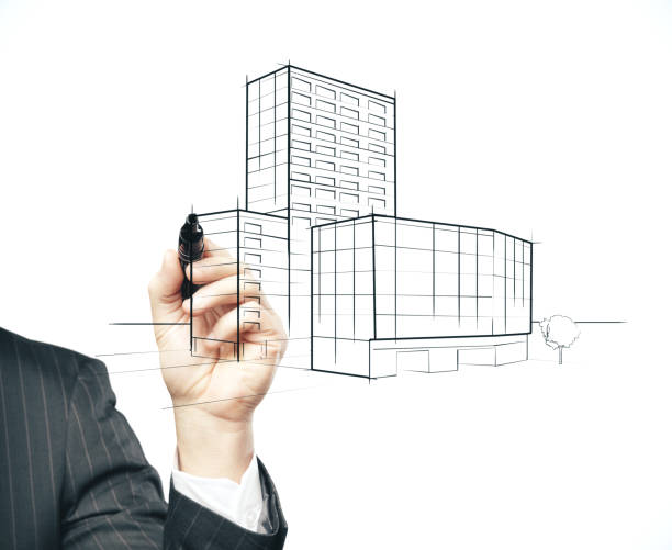 istock Businessman hand with pen drawing skyscraper 1212578357