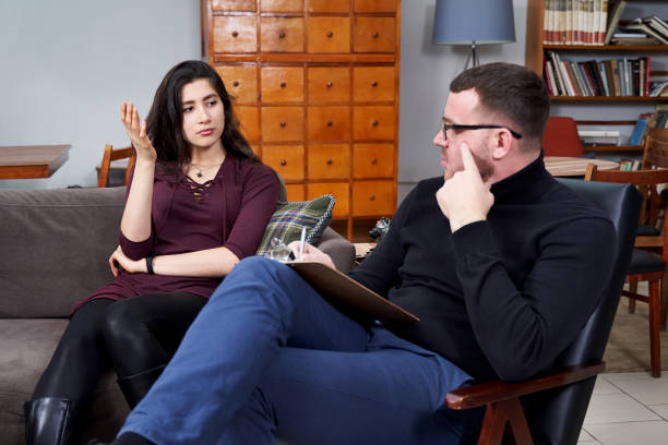 istock Young patient talking to her therapist who is making notes in private office 1212580940