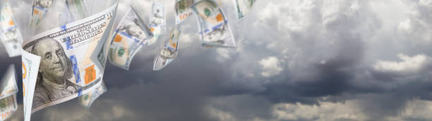 istock Several 100 Dollar Bills Falling From Stormy Cloudy Sky Banner 1212582203