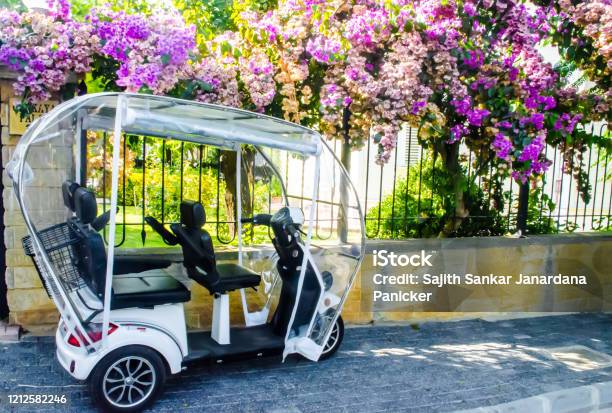 A Parked Eletric Tricycle On The Side Of A Wall And Fence Covered With Beautiful Flowers In The Prince Island Turkey Stock Photo - Download Image Now