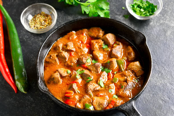 Peri-peri chicken livers Close up view of peri-peri chicken livers in frying pan over dark stone background. african culture food stock pictures, royalty-free photos & images