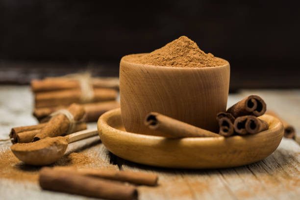 istock Bowl with cinnamon powder, cinnamon sticks and anise on white background, copy space 1212583615