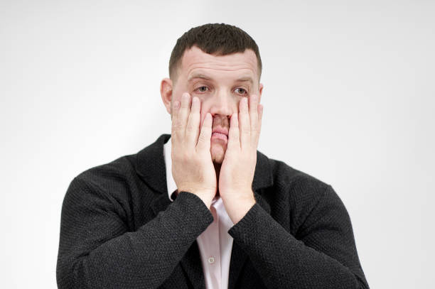 istock Stressed businessman with hands on the face over grey background with copy space, sadness and disappointed concept 1212584127
